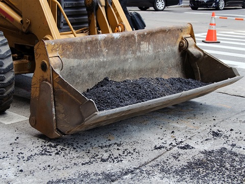 Front-loader-bucket-holds-asphalt-for-street-repair.jpg