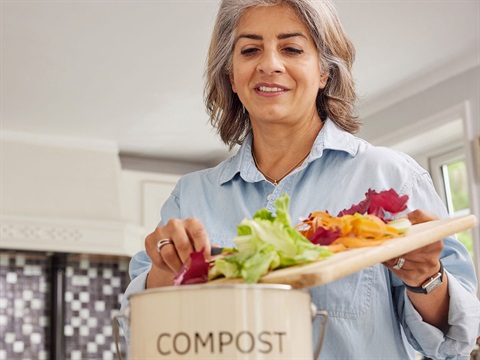 Woman-composts-vegetable-trimmings-in-her-kitchen.jpg