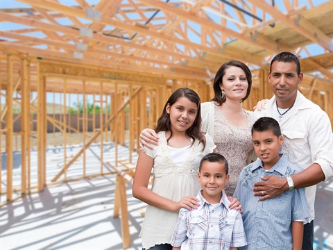 Family-in-front-of-new-home-wood-framing.jpg