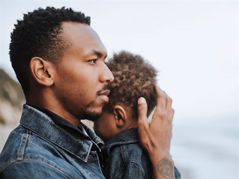 African-American-man-holds-young-child-and-supports-its-head.jpg