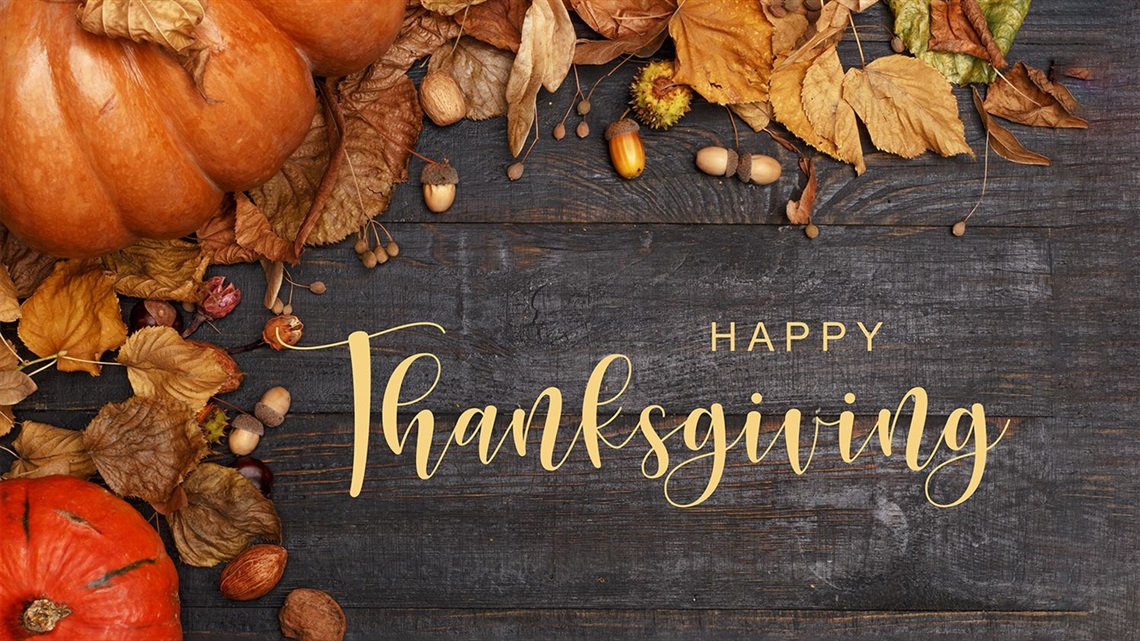 Happy-Thanksgiving-with-light-and-dark-orange-pumpkins-dried-leaves-and-acorns.jpg