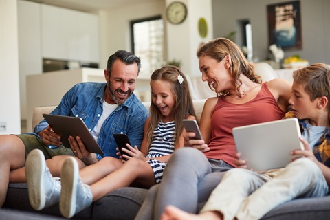 happy family smiling at mobile devices