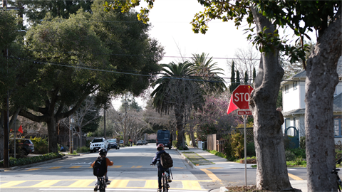 Two children riding bikes in residential street