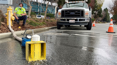 Crew member flushing water main using hydrant