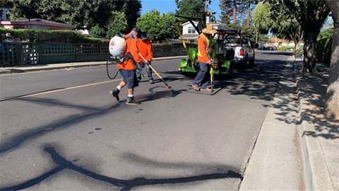 Public works filling cracks in street