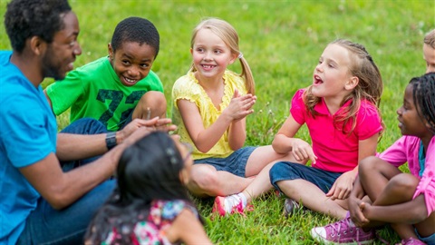 Children sitting in circle on grass at summer camp.jpg