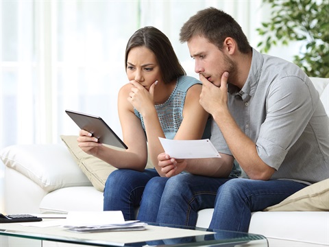 Couple-goes-over-their-bills-on-the-couch.jpg