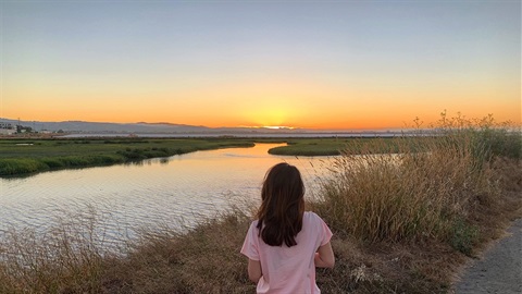 Girl-looks-toward-sunset-over-the-waterfront-at-Bedwell-Bayfront-Park.jpg