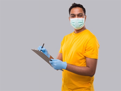 man-in-yellow-shirt-wears-mask-and-gloves-holding-clipboard.jpg