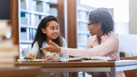 Mentor helping young girl in library.jpg