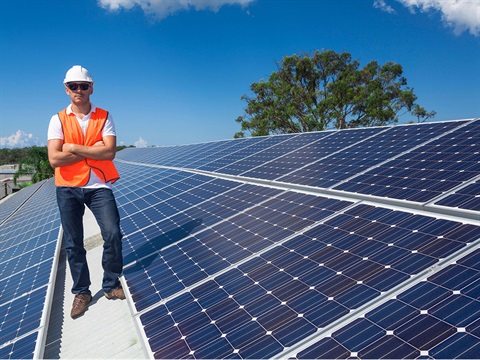 Contractor-stands-on-roof-next-to-solar-panels.jpg