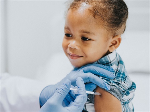 OpenCities-young-child-smiles-and-receives-COVID-19-vaccine.jpg