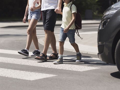 Parent-and-children-in-crosswalk-in-front-of-a-gray-car.jpg