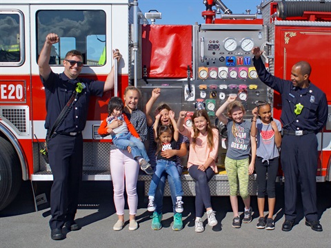 Two-fire-fighters-and-kids-in-front-of-fire-truck.jpg