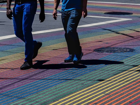 Two men walking on rainbow crosswalk (1).jpg