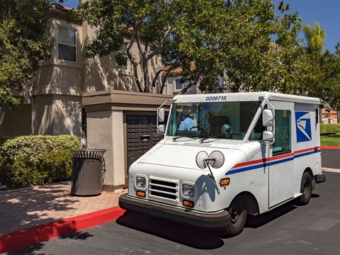 US-Postal-Service-mail-van-next-to-multifamily-complex-mailboxes.jpg