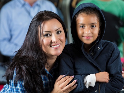 Woman-and-child-pose-while-child-tries-on-a-warm-coat.jpg