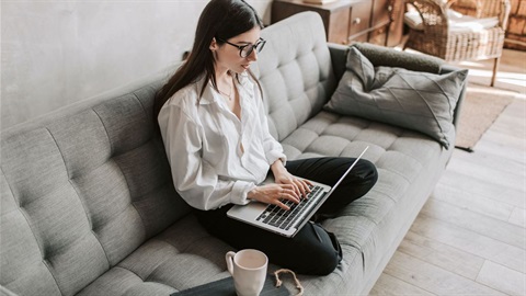 Woman sitting on couch working on laptop.jpg