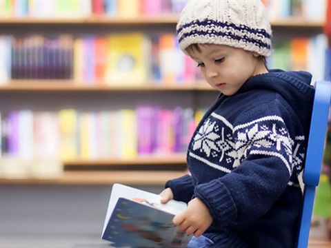 boy-reading-book-in-library