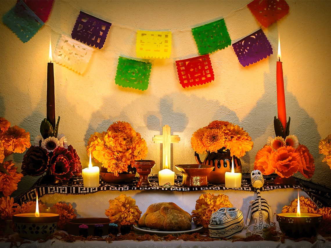Dia-de-los-Muertos-alter-with-candles-and-decorations